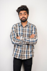 young hispanic bearded man wearing plaid shirt over white background with positive expression, has broad interested smile. Look there, please.looking for something or found something