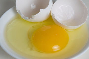 Egg yolk and shell on a plate isolate on a white background