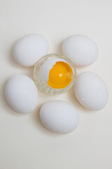 Many eggs and egg yolk in the shell on a white background