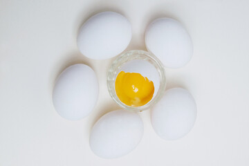 Many eggs and egg yolk in the shell on a white background