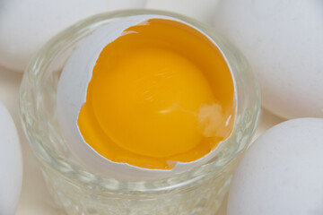Many eggs and egg yolk macro in the shell on a white background