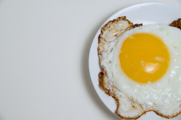 Fried egg on white plate and boiled egg in shell isolate on white background with space for text. Concept of high prices for eggs and food. Concept of healthy eating