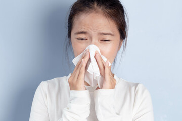 Sick Asian woman feeling unhealthy, seasonal health problems, chronic allergic rhinitis, colds, first symptoms of flu, virus, a respiratory infection.
