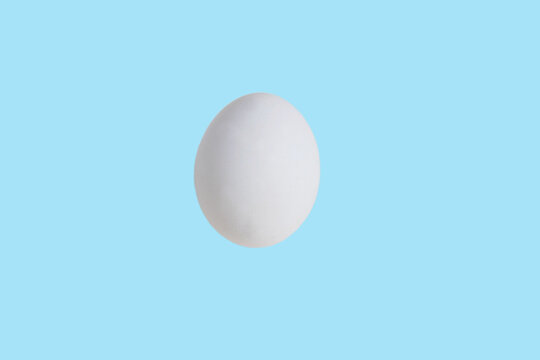 One white egg isolate on a turquoise background. Happy Easter concept