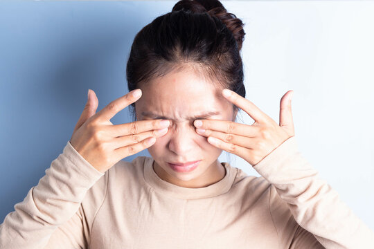 Close-up of young woman rubbing irritated eyes, eye irritation, eye rubbing, eye problems, migraine pain