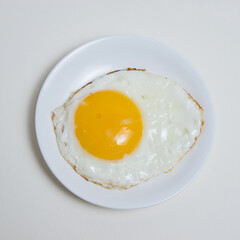 Fried egg on white plate isolate on white background flatlay top view