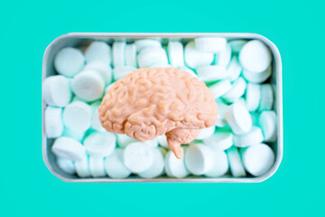 Human brain over a tin box of breath mints