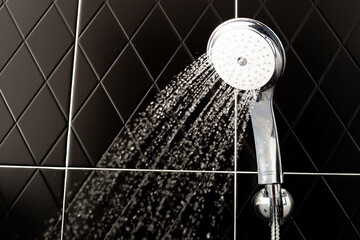 Shower with running water in a black room