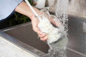 Woman washing glass bottles with a bottle brush
