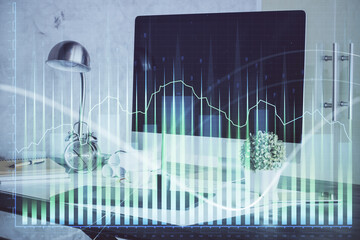 Stock market graph on background with desk and personal computer. Double exposure. Concept of financial analysis.