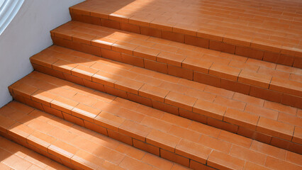 Brown tile steps with white banister of the old vintage staircase outside of home