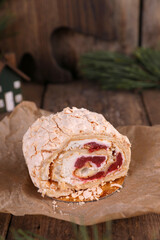 Meringue roll with strawberries on a wooden table