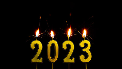 Holiday background Happy New Year 2023. Numbers of the year 2023 made by gold sparkler candle number. celebrating New Year's holiday.isolated on black background 
