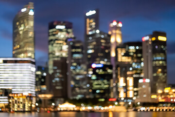 Fototapeta na wymiar Blurred image bokeh of skyscraper around Marina Bay in Singapore at night
