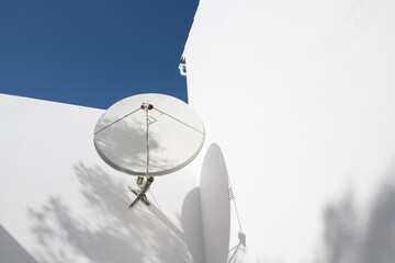 TV Satellite dish on the wall of a white house