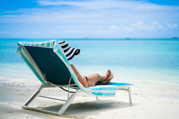 Young Woman In Bikini Sunbathing On Deck Chair