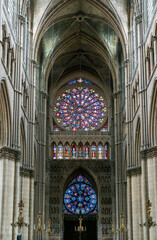 view of the reverse side of the West Facade of the Reims Cathedral with colorful stained glass windows and sculptures