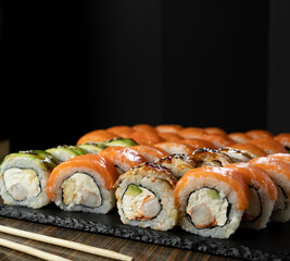 Sushi Set with salmon, prawn and sushi rolls philadelphia served on served on stone slate. Japanese Food