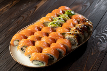 Sushi roll set Philadelphia with salmon, avocado, cream cheese on wooden background. Sushi menu. Japanese food