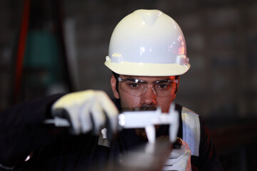 Industrial Worker Inspector Measuring detail with Vernier Caliper in Factory Workshop