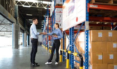 Distribution warehouse manager and client businesswoman using digital tablet checking inventory...