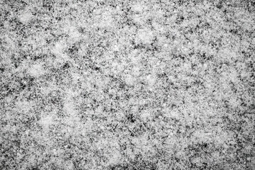 Abstract pattern close -up white snow on the black surface for Christmas and New Year, natural contrast white background with snow crystals, geometric winter pattern in macro photo, flatlay