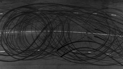 Top view tire tracks texture and background, Asphalt texture with line and tire marks, Automobile automotive tire skid mark on race track, Abstract texture car drift tire skid mark. © Darunrat