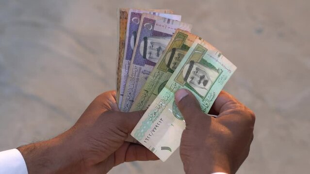 man counting Saudi Arab riyals, Saudi Arabia Currency