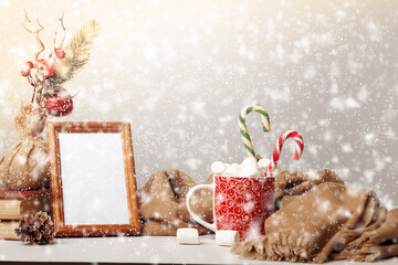Merry Christmas. Marshmallow mug photo frame warm blanket scarf with defocused snowfall.