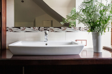 Modern bathroom interior with stylish mirror and vessel sink.