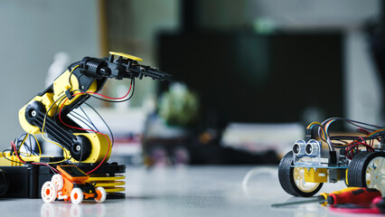 Robot arm and robotic cars project, using computers and coding. technology of robotics programing...