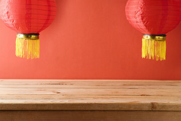 Festive background for Chinese New Year celebration with empty wooden table and traditional red...