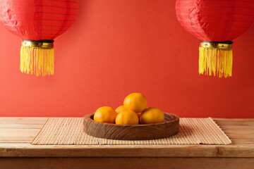 Chinese New Year celebration background with orange fruit on table and traditional red lanterns