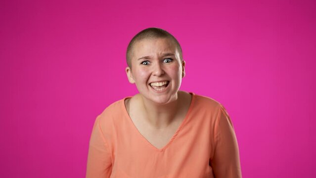 Portrait of surprised excited young gender fluid non binary woman 20s celebrate great success, winner, AMAZING, give thumbs up, isolated on pink background.