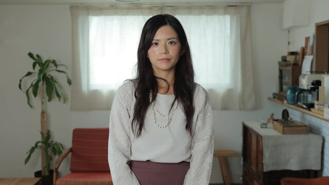 Beautiful Japanese woman opens her eyes and stares the camera. Emotionless, Still, Protest.