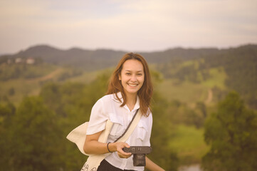 Happy smiling young woman traveller hand holding her camera