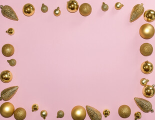 Top view Christmas new year flat lay on pink background. Fir branches with golden christmas balls and decorations. 

