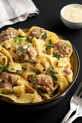 Homemade One-Pot Swedish Meatball Pasta in a Bowl on a black background, side view. Close-up.