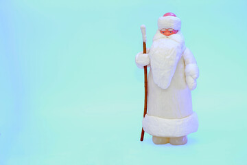 Santa claus with staff in white fur coat isolated on snow blue
