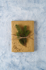 Christmas gift box with fir branches decorations on delicate blue backround. Top view.