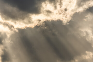Naklejka na ściany i meble Beams of light of sun's rays through clouds in morning.