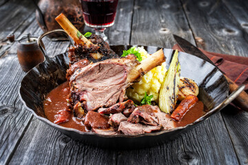 Traditional Greek barbecue lamb knuckles with mashed potatoes and vegetables in red wine sauce...