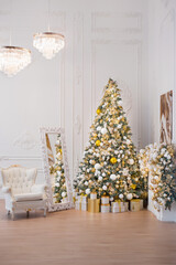 Interior of luxury interior with fireplace, comfortable sofa and chandelier decorated with Christmas tree and gifts
