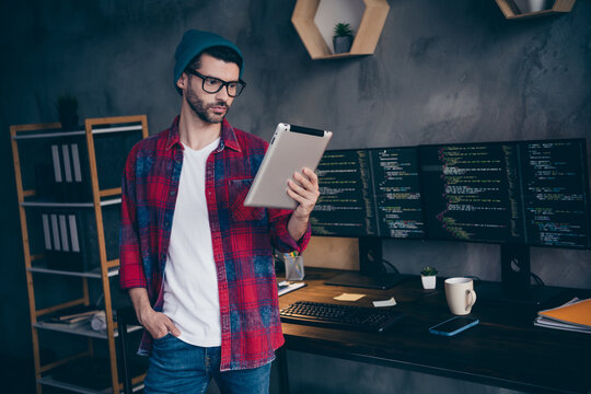Photo of serious thoughtful guy dressed eyewear making app adaptation ebook modern device indoors workstation workshop home