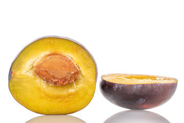 Two halves of a ripe plum, close-up, isolated on a white background.