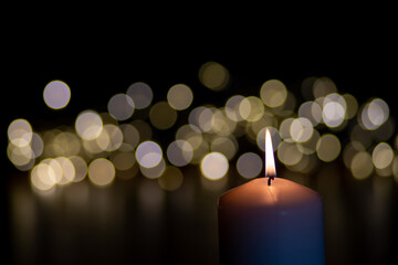 candles in the dark with Christmas lights in the background, copy space