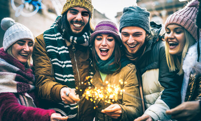 Happy friends celebrating new year eve with sparklers  - Winter lifestyle concept with young people...