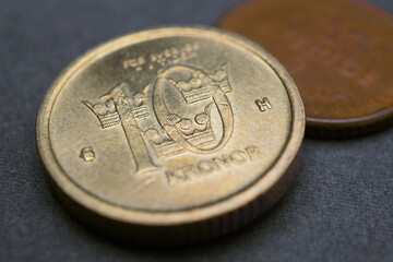 Swedish coins lie on a dark surface. 10 krona coin closeup. National currency of Sweden. Money...