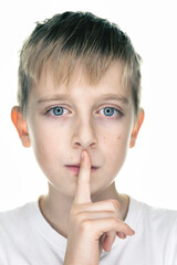 A child with finger on lips, sign quiet, isolated on white background
