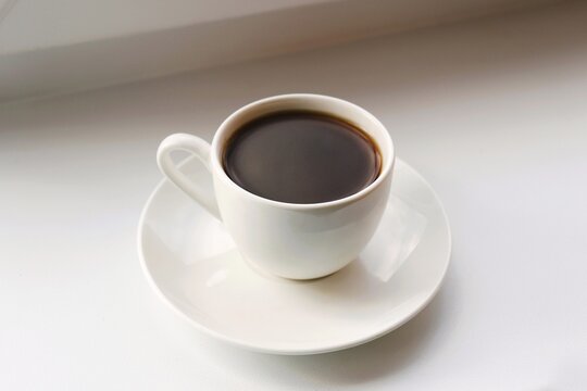 A small cup of coffee on the table. Closeup, top view photography